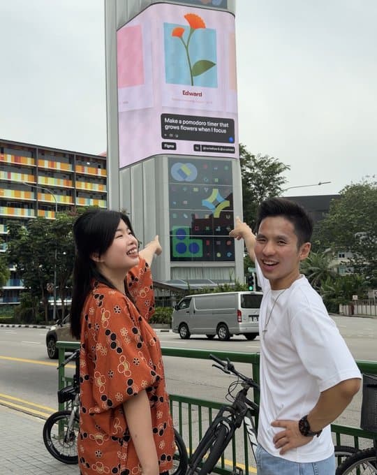 Edward with a guest in front of a digital billboard